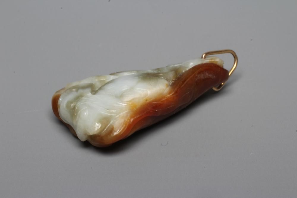 A CHINESE JADE PENDANT, one side carved as a hare (?) beside a flower, the other with a persimmon, Image