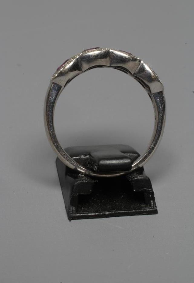 A HALF HOOP DRESS RING, the four collet set pink topaz (?) within borders of small point set Image