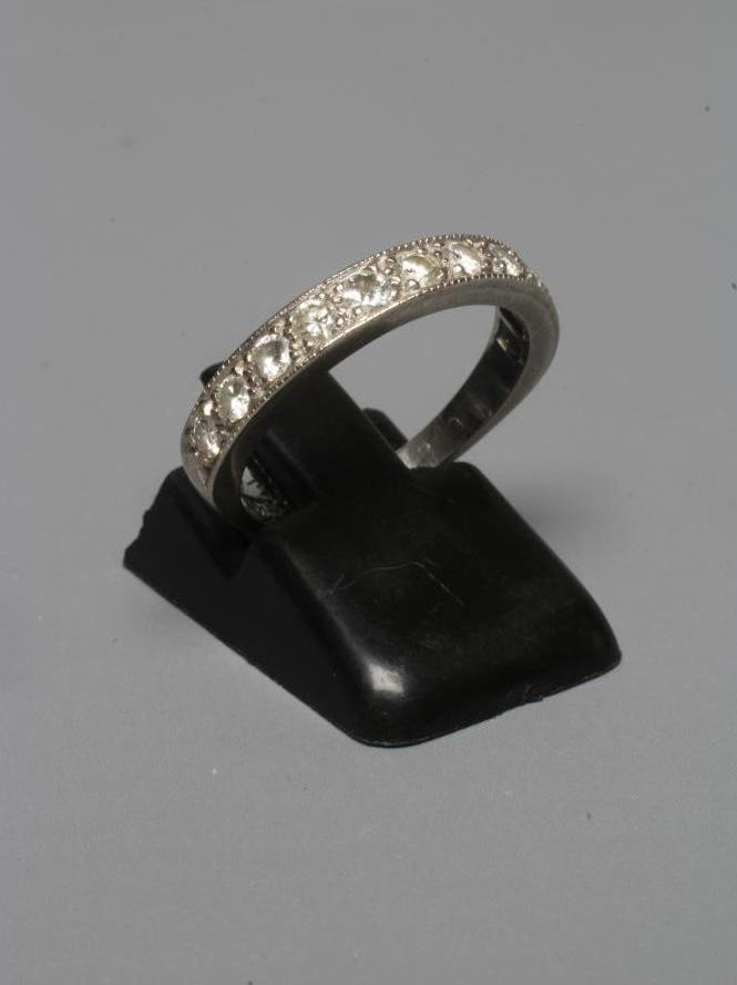 A DIAMOND HALF HOOP ETERNITY RING, the eleven small brilliants pave set to a white shank stamped Image