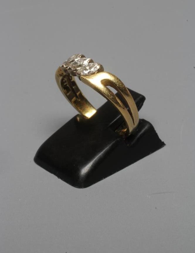 A THREE STONE DIAMOND RING, the marquise cut stones claw set to open shoulders and a plain 18ct gold Image