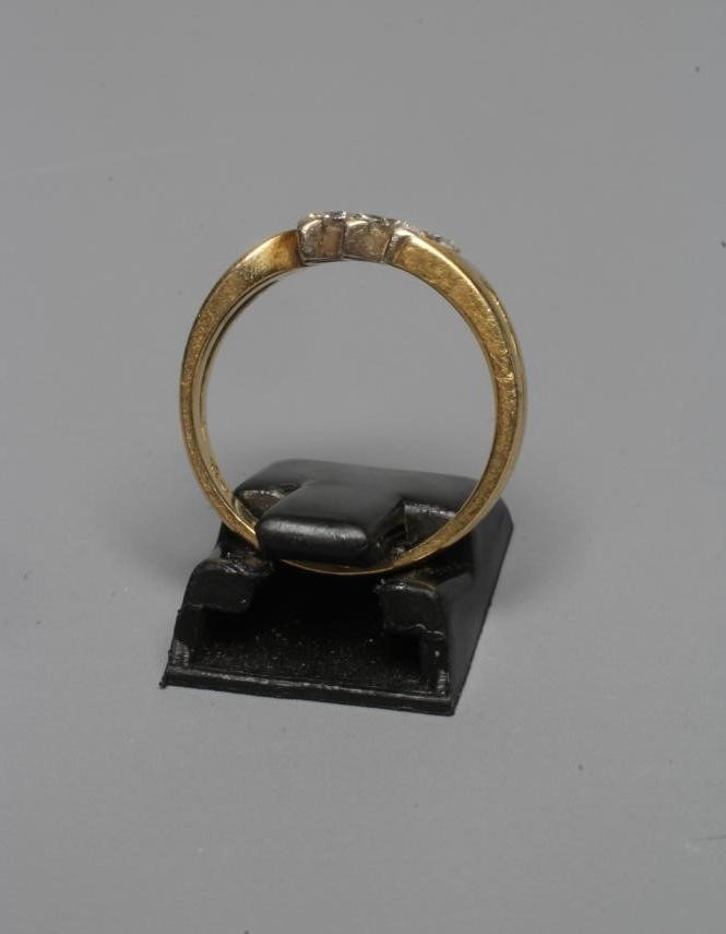 A THREE STONE DIAMOND RING, the marquise cut stones claw set to open shoulders and a plain 18ct gold Image