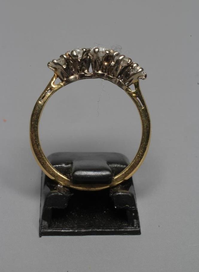 A FIVE STONE DIAMOND RING, the old brilliant cut stones claw set to a plain shank stamped 18ct, size Image