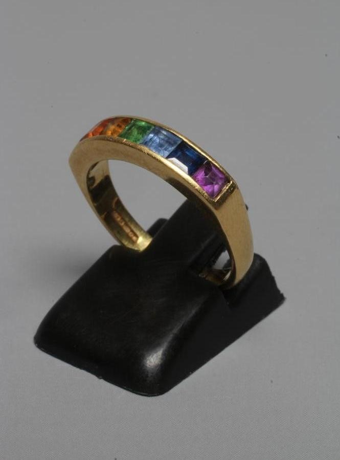 A MULTI-GEM HALF HOOP RING, the seven square cut stones including garnet, aquamarine and amethyst Image