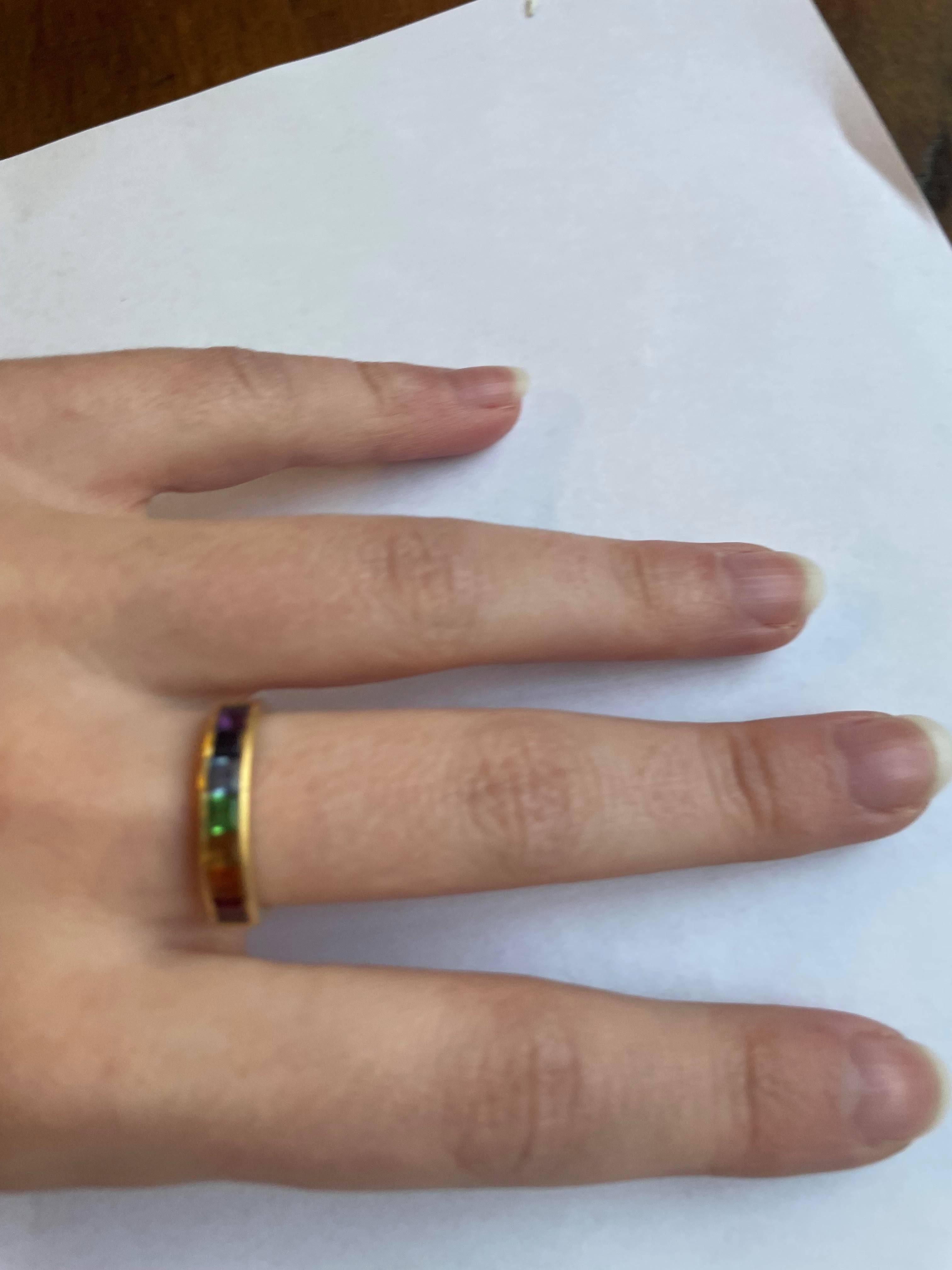 A MULTI-GEM HALF HOOP RING, the seven square cut stones including garnet, aquamarine and amethyst Image