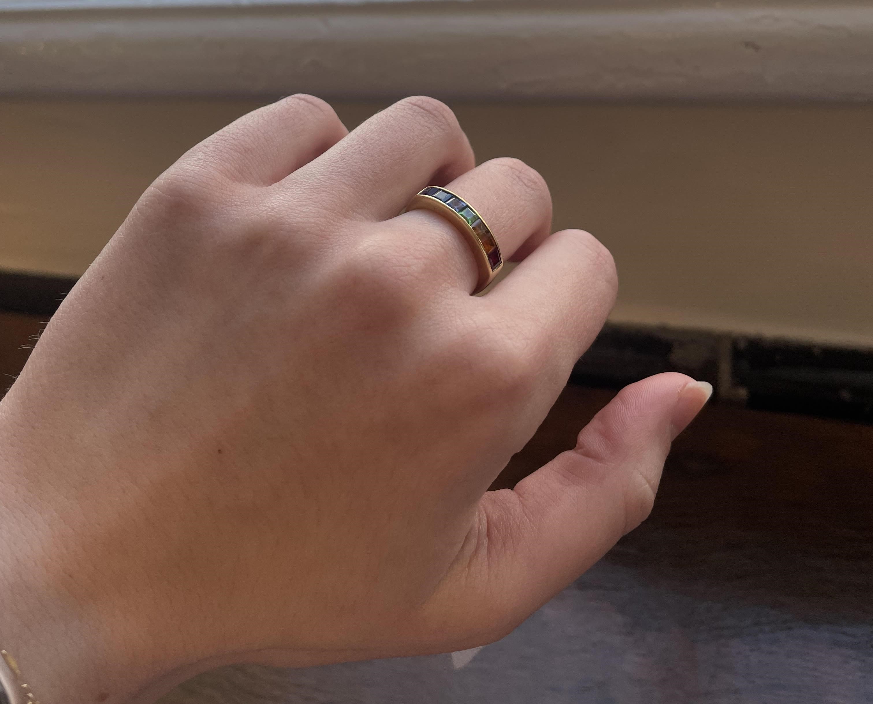 A MULTI-GEM HALF HOOP RING, the seven square cut stones including garnet, aquamarine and amethyst Image