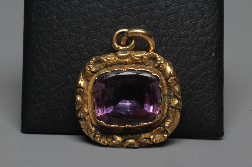 A VICTORIAN AMETHYST PENDANT, the facet cut cushion shaped stone collet set in a foliate carved Image
