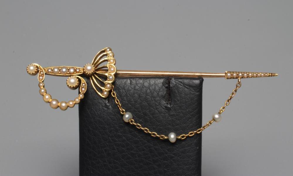 AN EDWARDIAN NOVELTY JABOT PIN in the form of a court sword with seed pearl set basket hilt and Image