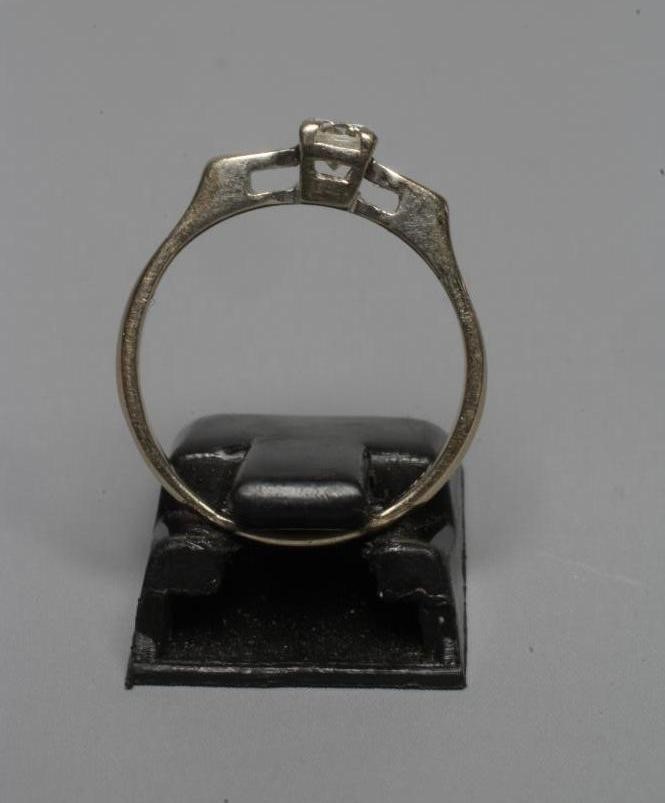 A SOLITAIRE DIAMOND RING, the brilliant cut stone of approximately 0.12cts claw set to angular Image