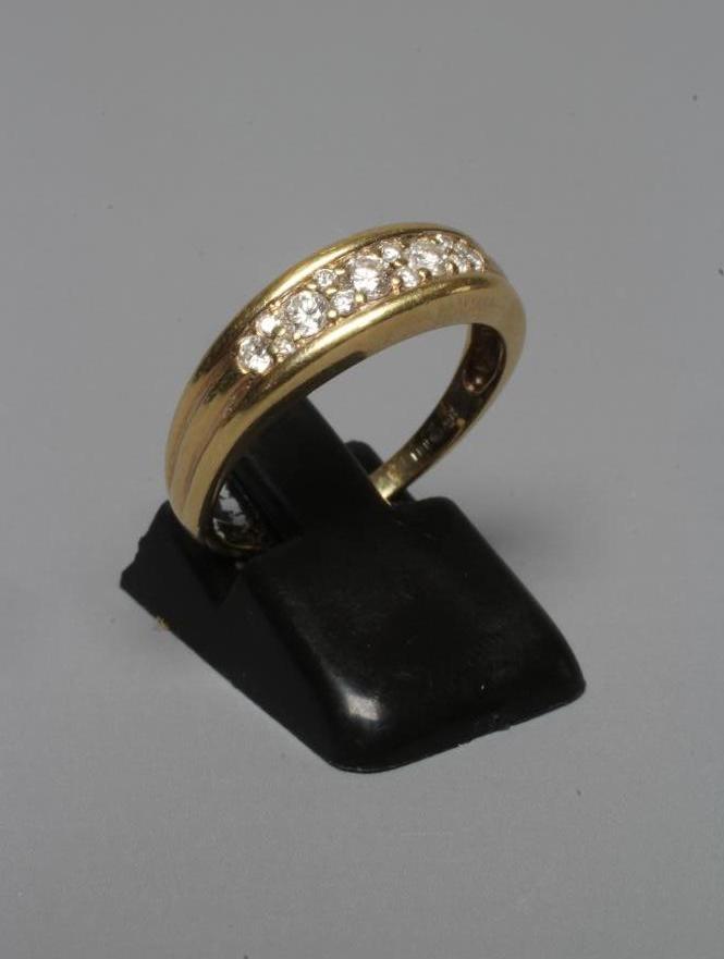 A DIAMOND RING pave set with five graduating brilliant cut stones with four pairs of diamond points Image