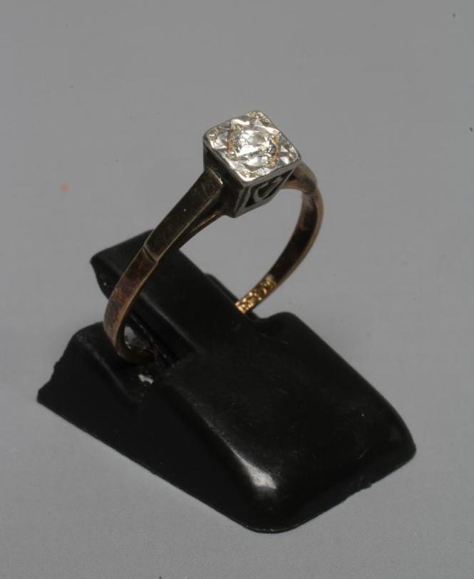 A SOLITAIRE DIAMOND RING, the old brilliant cut stone point set in a square plaque to a plain shank Image
