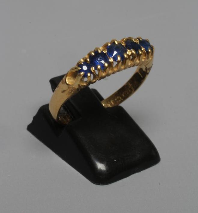 A MID VICTORIAN FIVE STONE SAPPHIRE RING, the graduated facet cut stones claw set to a plain 18ct Image