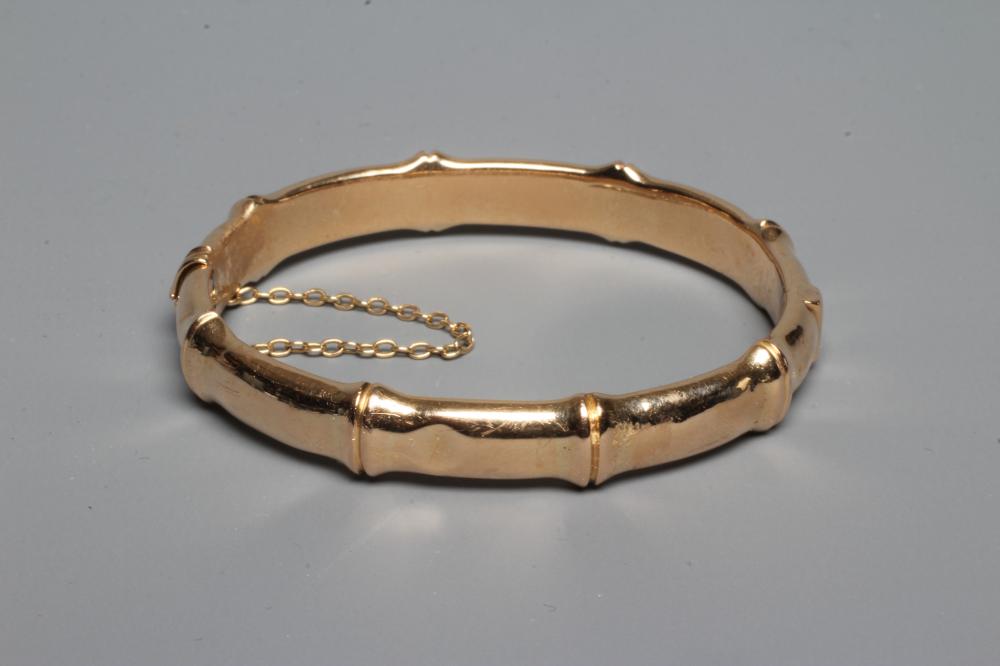 A LATE VICTORIAN FAUX BAMBOO STIFF HINGED BANGLE, unmarked, with safety chain (Est. plus 24% premium Image