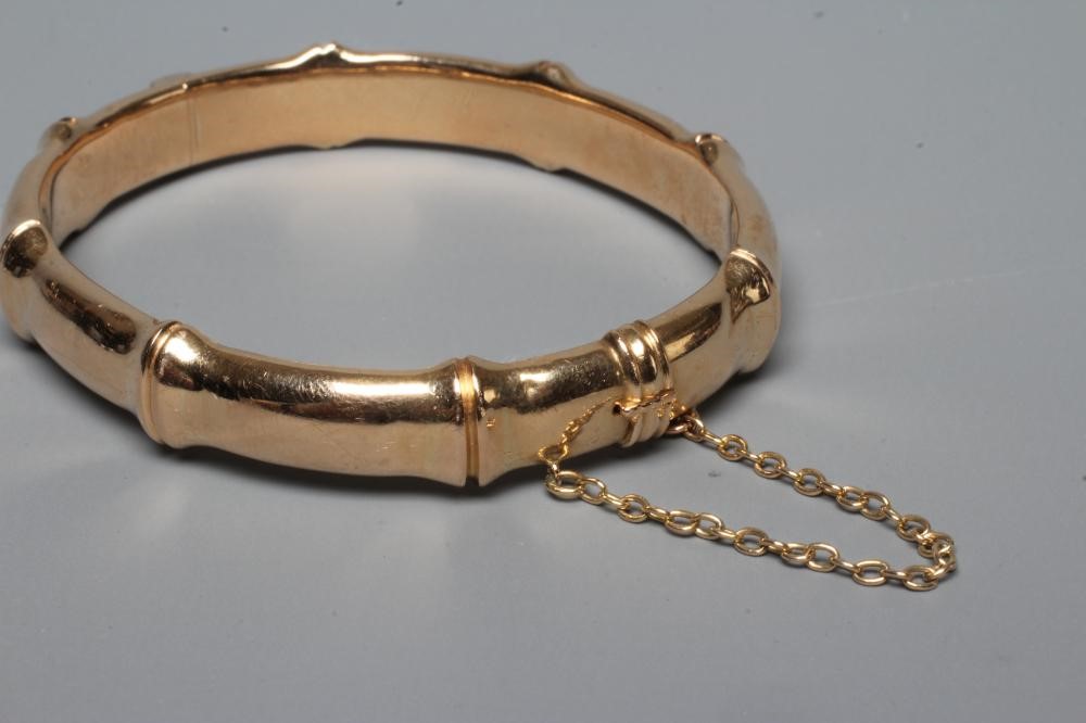 A LATE VICTORIAN FAUX BAMBOO STIFF HINGED BANGLE, unmarked, with safety chain (Est. plus 24% premium Image