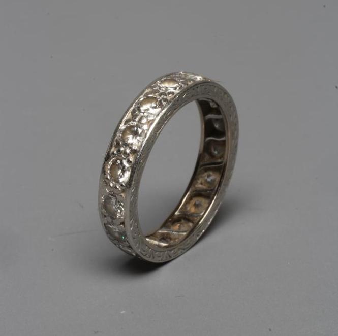 A DIAMOND ETERNITY RING, the numerous brilliant cut stones pave set to an unmarked engraved white Image