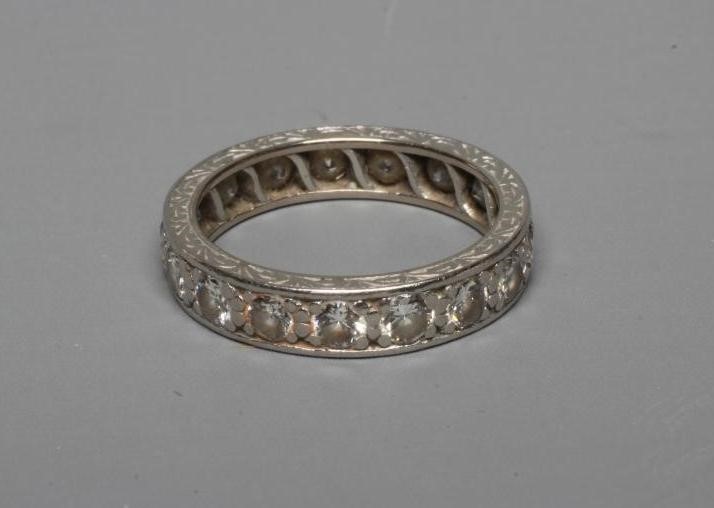 A DIAMOND ETERNITY RING, the numerous brilliant cut stones pave set to an unmarked engraved white Image