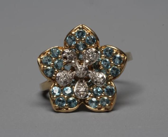 A MODERN FLOWERHEAD CLUSTER RING point set with small mix cut diamonds to the centre within blue Image