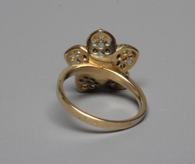 A MODERN FLOWERHEAD CLUSTER RING point set with small mix cut diamonds to the centre within blue Image
