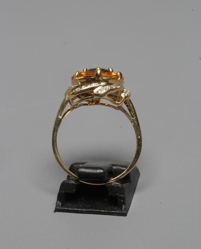 A MULTI-GEM COCKTAIL RING centred by a circular facet cut garnet within a border of six oval facet Image