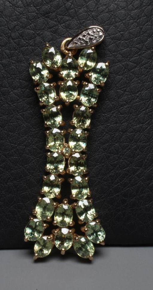 A PERIDOT PENDANT of stylised X form on a diamond point set tear drop bale, applied plaque stamped Image