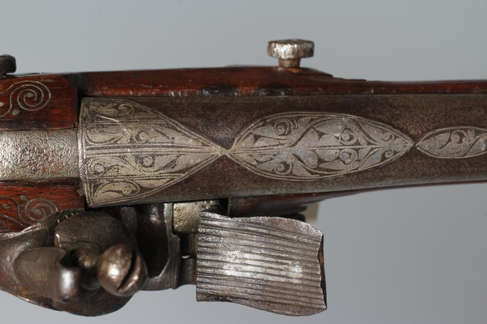 A FLINTLOCK BLUNDERBUSS PISTOL with 12" white metal inlaid barrel, carved and inlaid wood stock and Image