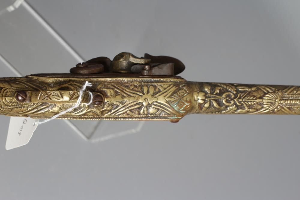A FLINTLOCK PISTOL with 12" barrel, plain action and highly decorative foliate designed brass stock, Image