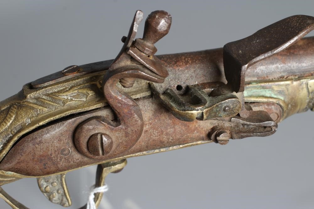 A FLINTLOCK PISTOL with 12" barrel, plain action and highly decorative foliate designed brass stock, Image