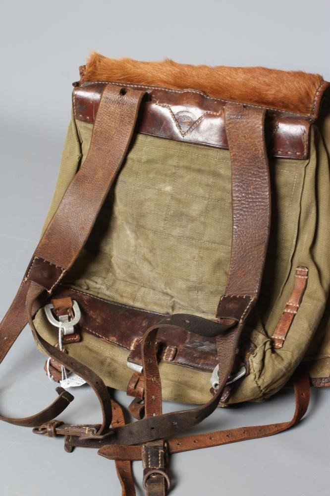 A GERMAN WWII TORNISTER BACKPACK, the canvas body with leather strapping, stamped "Heinrich Sattel, Image