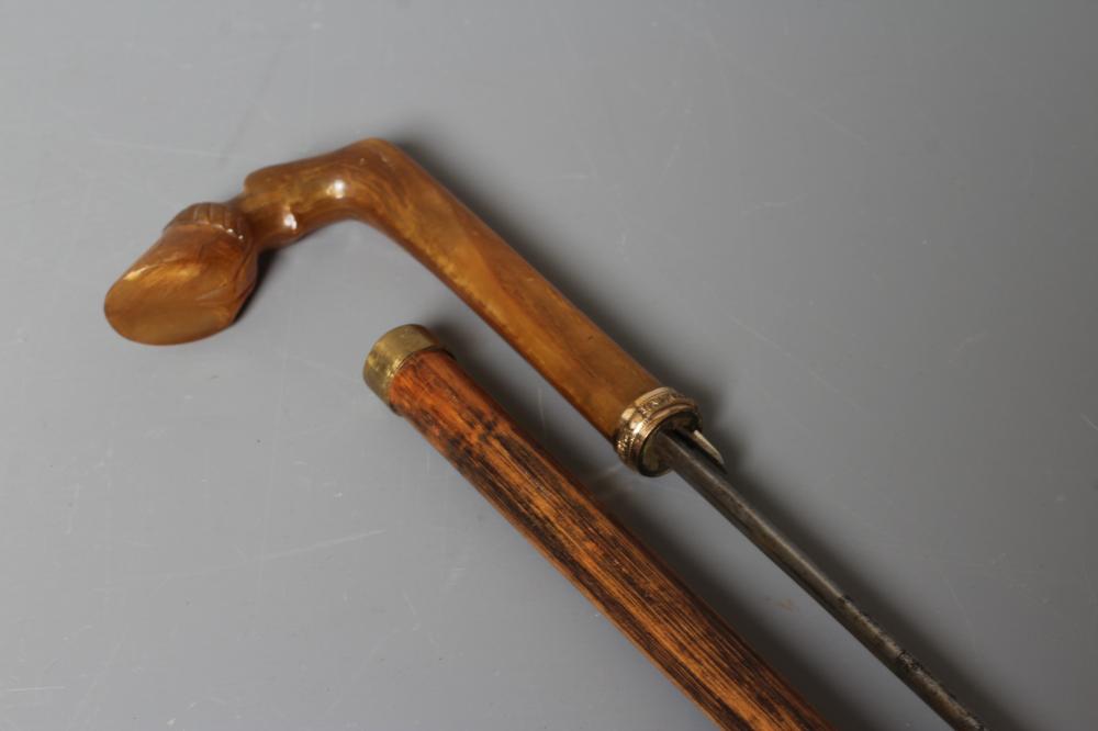 A LATE VICTORIAN SWORD STICK with a button released 26" flat section blade, horn grip carved as a Image