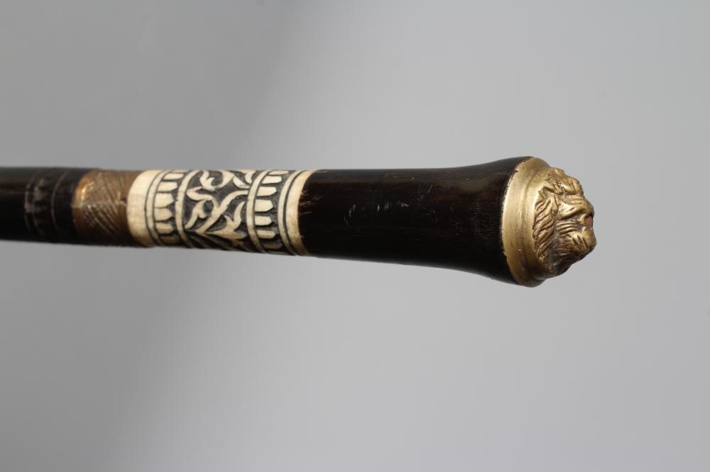 A SWAGGER SWORD STICK with 13 3/4" twist release ferrule, carved bone section to grip and lion Image