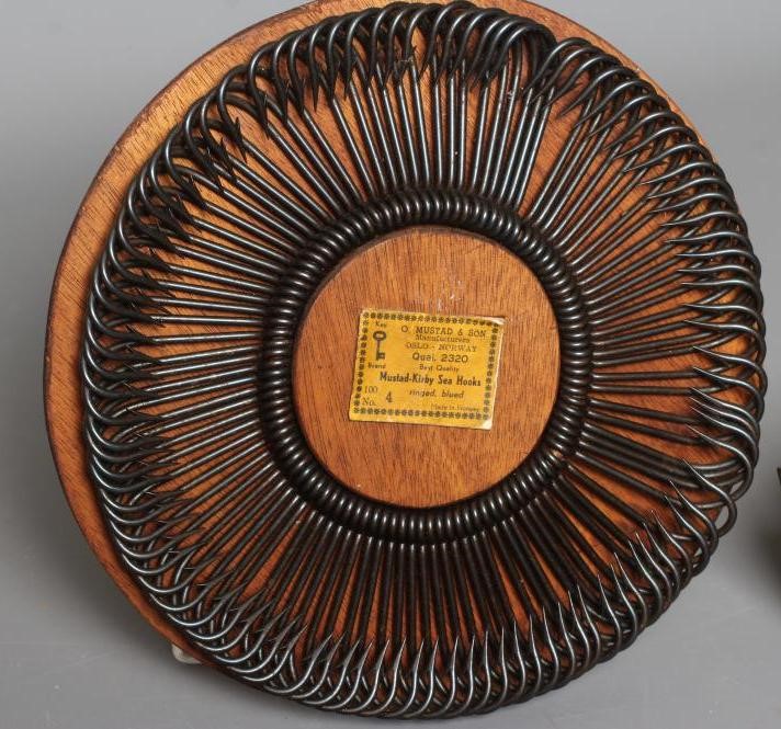A MUSTAD & SON SEA HOOKS ADVERTISING BOARD, together with two antique star back reels and two gaffs Image