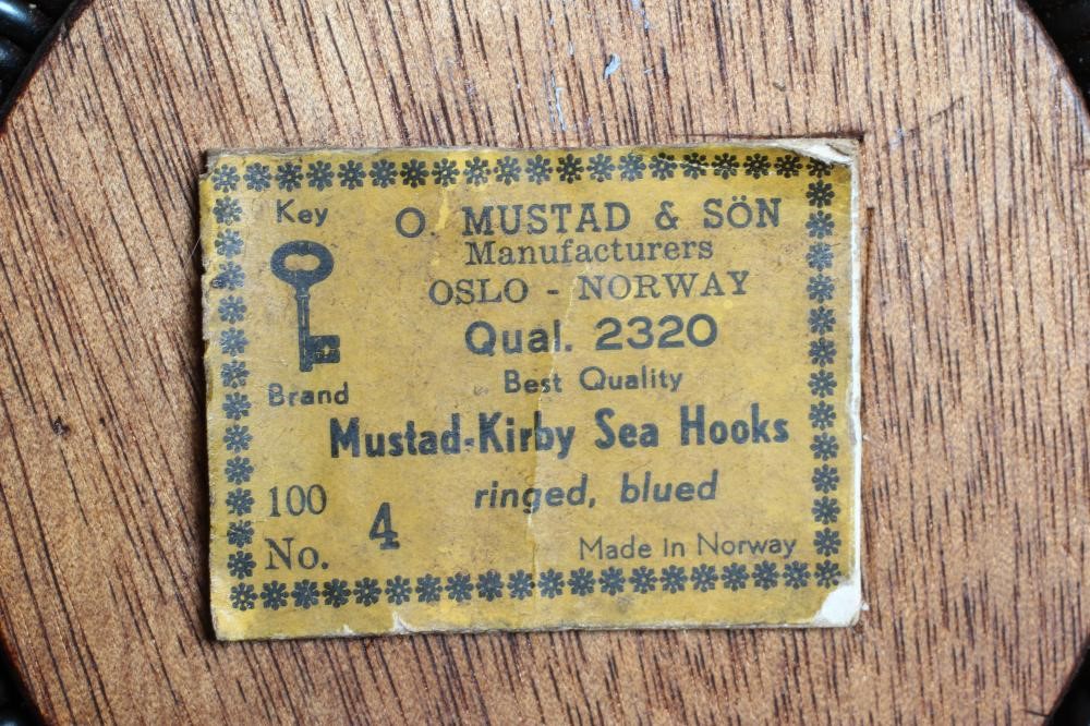 A MUSTAD & SON SEA HOOKS ADVERTISING BOARD, together with two antique star back reels and two gaffs Image