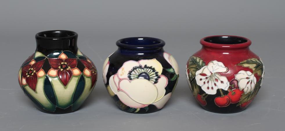 THREE MOORCROFT POTTERY SMALL VASES all of squat globular form and comprising Cherry Blossom Image