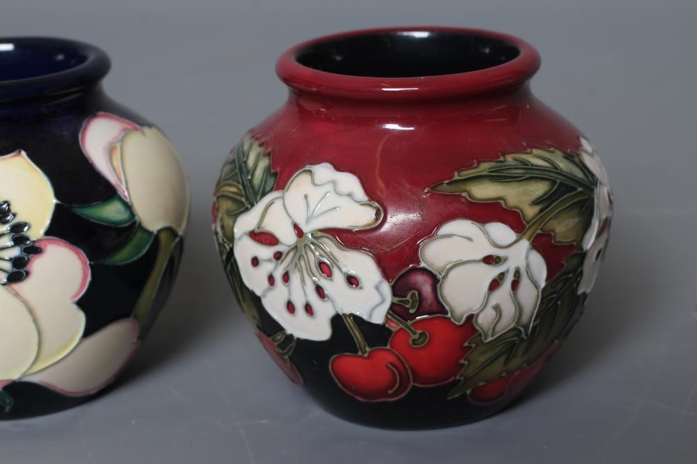 THREE MOORCROFT POTTERY SMALL VASES all of squat globular form and comprising Cherry Blossom Image