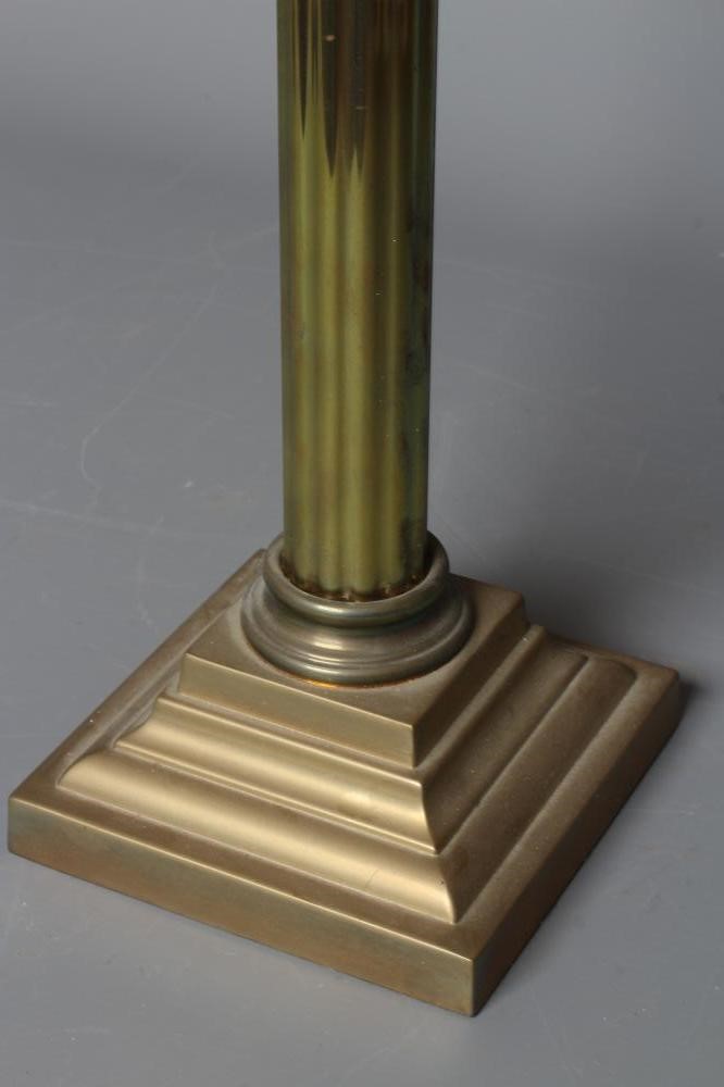 A VICTORIAN BRASS CORINTHIAN COLUMN OIL LAMP with etched cranberry spherical shade and clear chimney Image