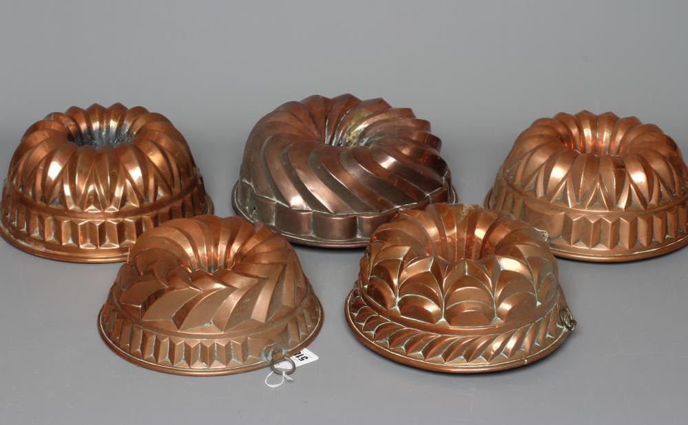 FIVE VICTORIAN COPPER BUNDT MOULDS comprising a pair with hanging loops, 10" diameter, a larger tin, Image
