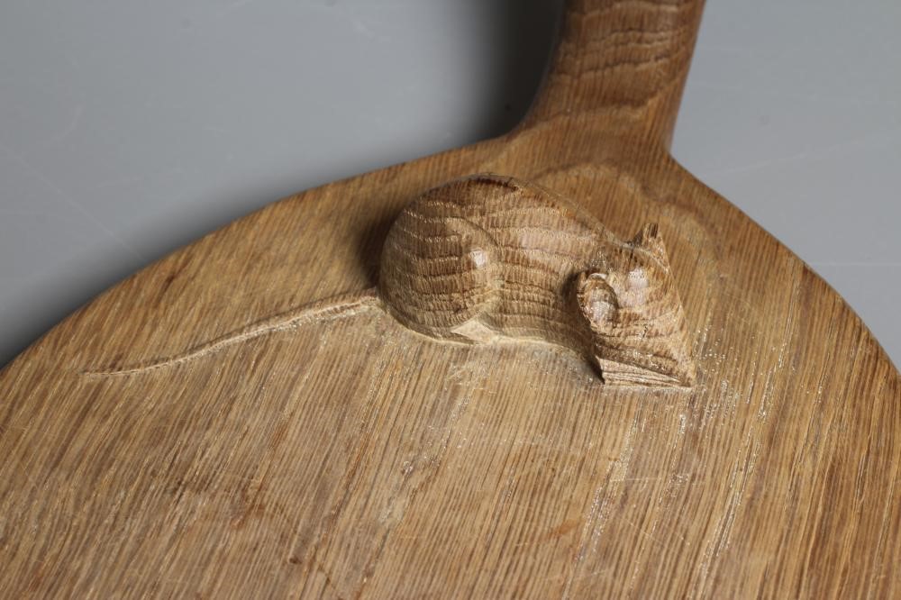 A ROBERT THOMPSON OAK CHEESEBOARD of oval form with carved mouse trademark in high relief, 14 1/2" Image
