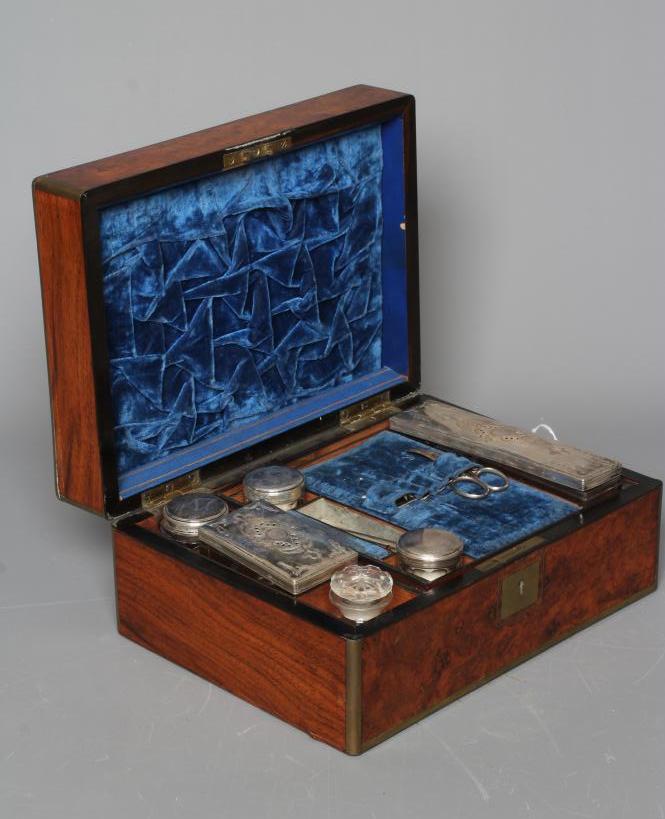 A VICTORIAN OBLONG BURR WALNUT AND BRASS BOUND TRAVELLING VANITY BOX with blue velvet lined fitted Image
