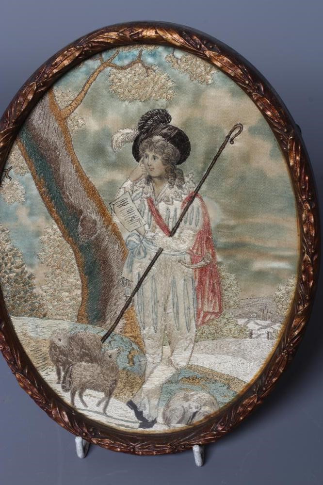 A PAIR OF REGENCY OVAL SILK NEEDLEWORKS worked with a shepherd and a companion in rural landscapes, Image