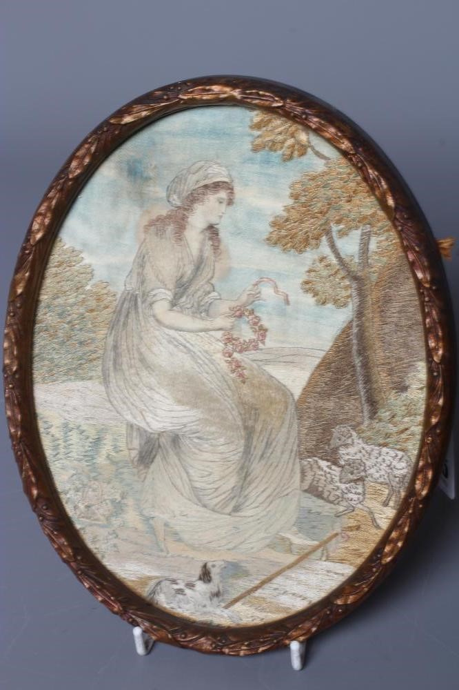 A PAIR OF REGENCY OVAL SILK NEEDLEWORKS worked with a shepherd and a companion in rural landscapes, Image
