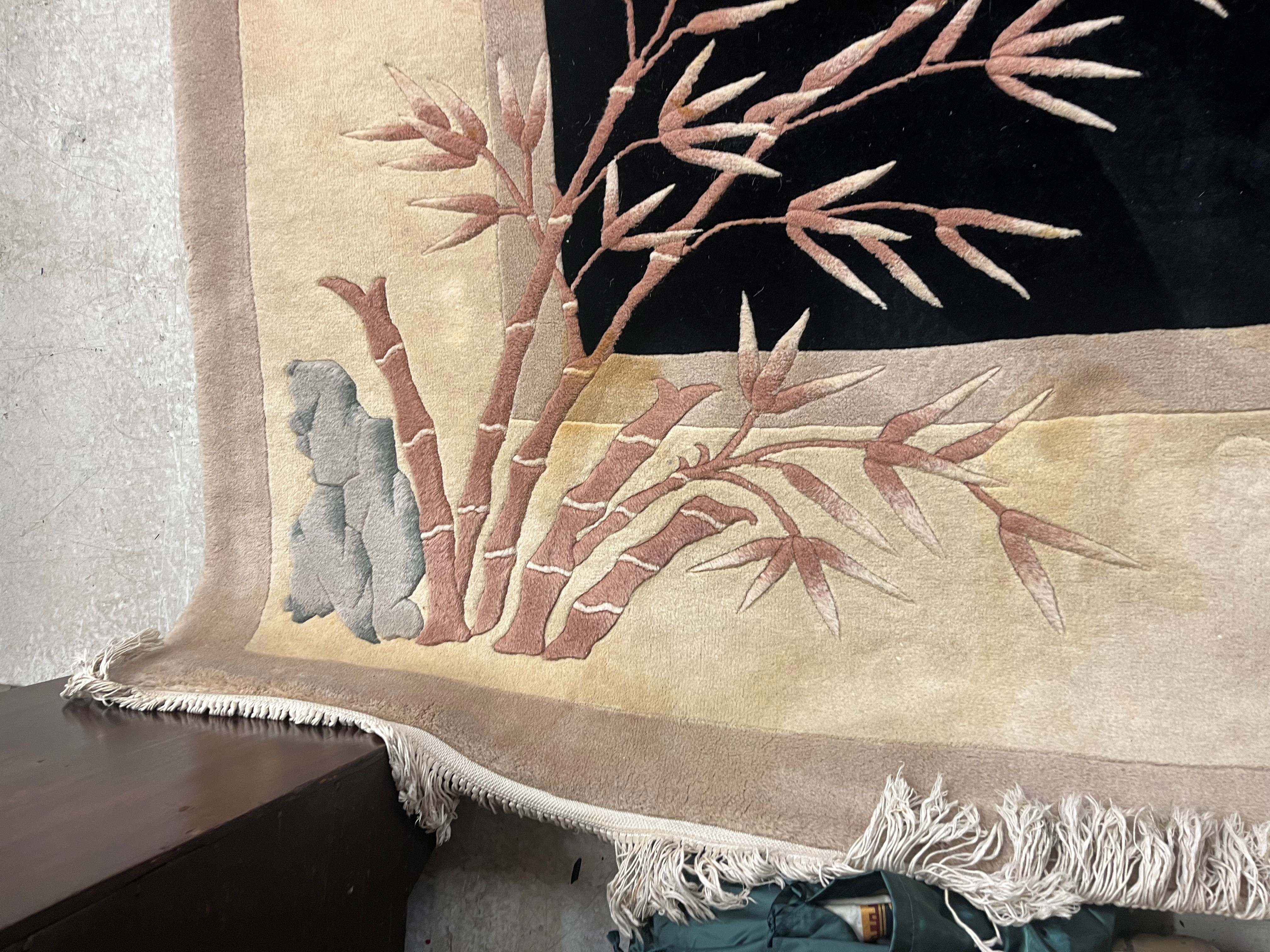 A CHINESE WASHED AND FRINGED CARPET, modern, the black field within a two tone champagne border, Image