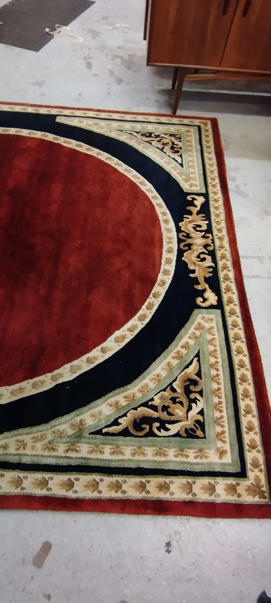 A WOOL RUG, modern, the black field centred by a large rust gul with cream border and conforming Image