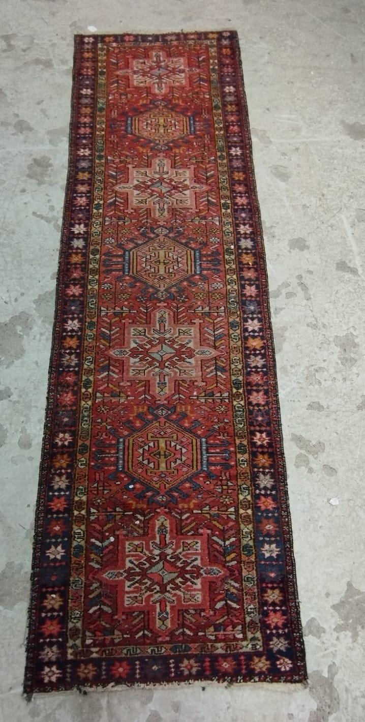 A NORTH WEST PERSIAN RUNNER, c.1900, the red field with alternating ivory and navy guls, within navy Image