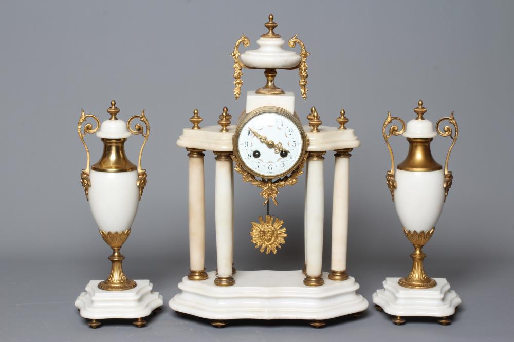A FRENCH WHITE ONYX AND GILT METAL CLOCK GARNITURE Image