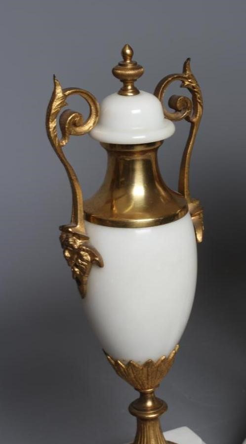 A FRENCH WHITE ONYX AND GILT METAL CLOCK GARNITURE Image