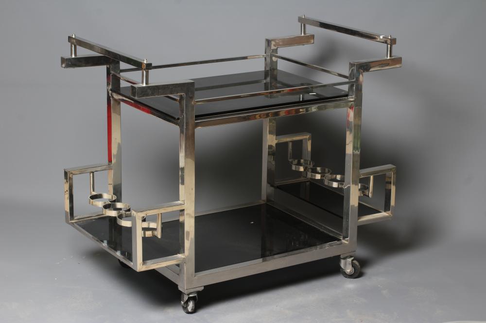 AN ART DECO CHROME FRAMED TWO TIER DRINKS TROLLEY of oblong form with black glass shelves Image