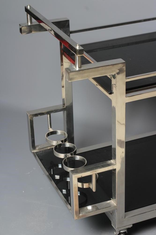 AN ART DECO CHROME FRAMED TWO TIER DRINKS TROLLEY of oblong form with black glass shelves Image