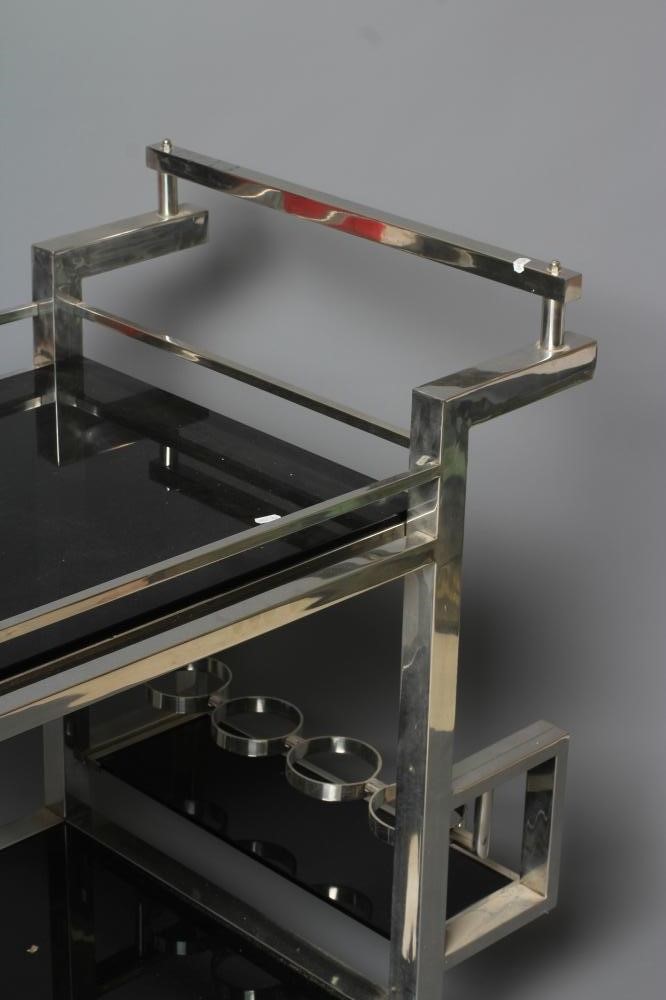 AN ART DECO CHROME FRAMED TWO TIER DRINKS TROLLEY of oblong form with black glass shelves Image