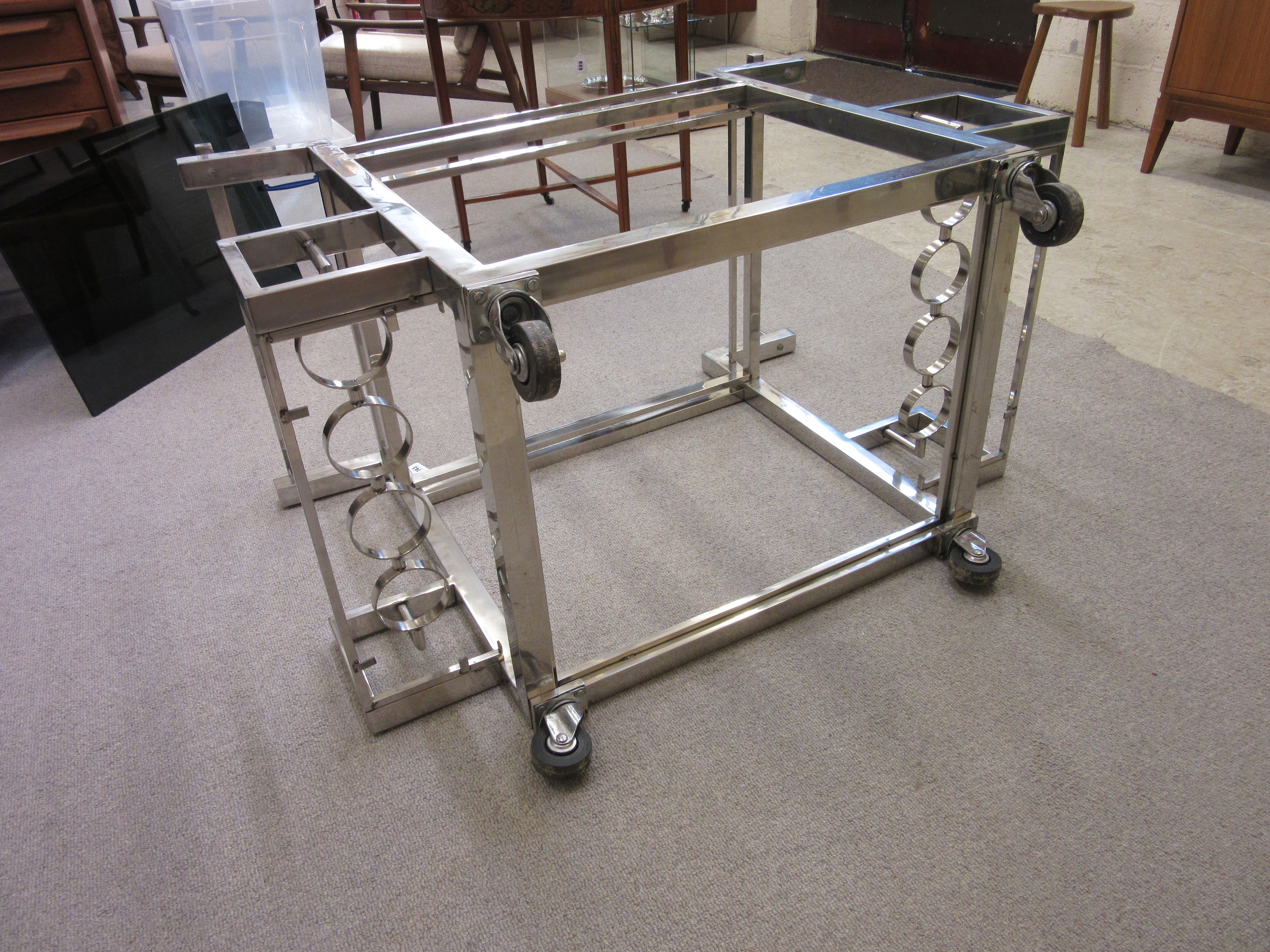 AN ART DECO CHROME FRAMED TWO TIER DRINKS TROLLEY of oblong form with black glass shelves Image