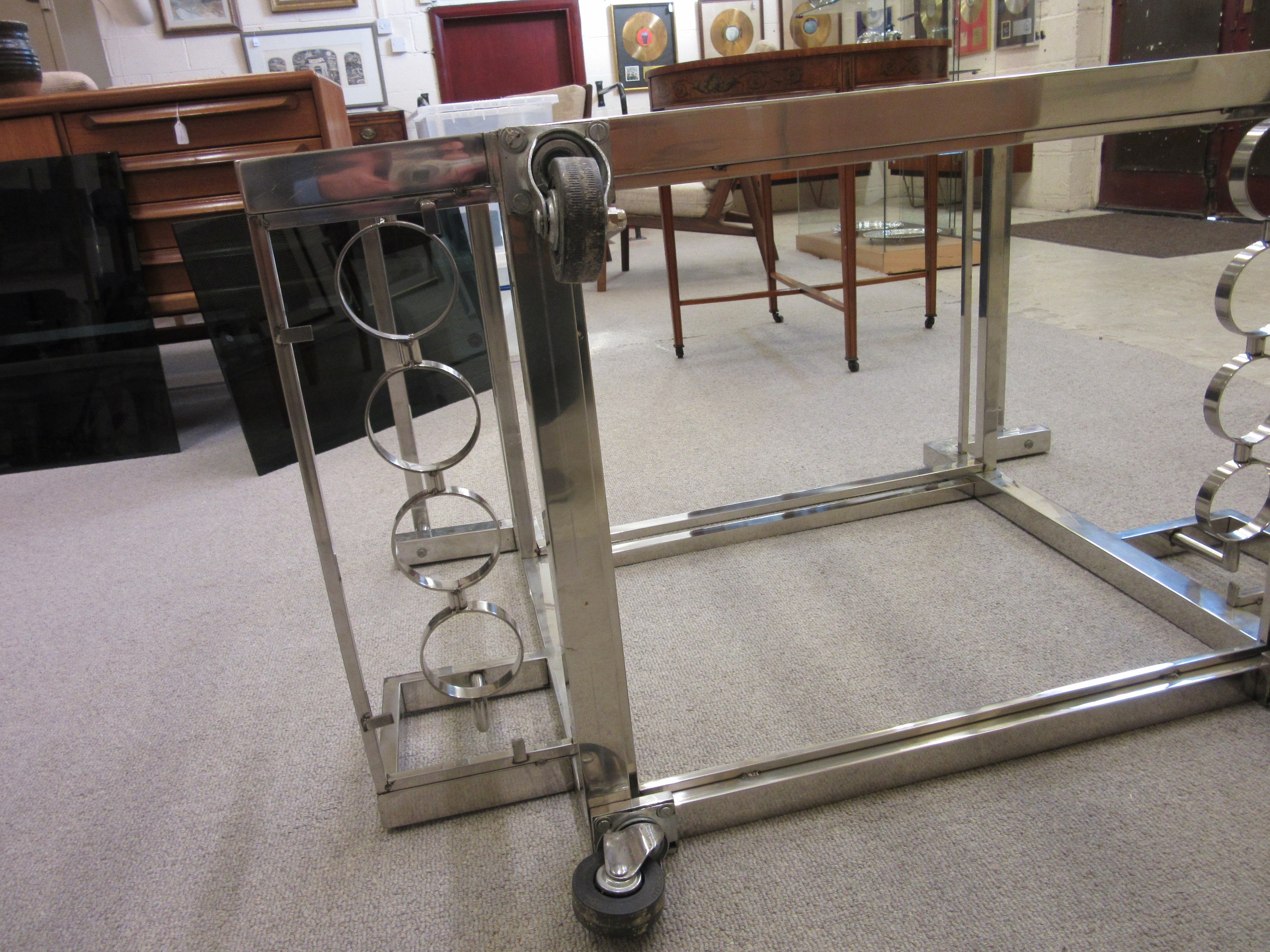 AN ART DECO CHROME FRAMED TWO TIER DRINKS TROLLEY of oblong form with black glass shelves Image
