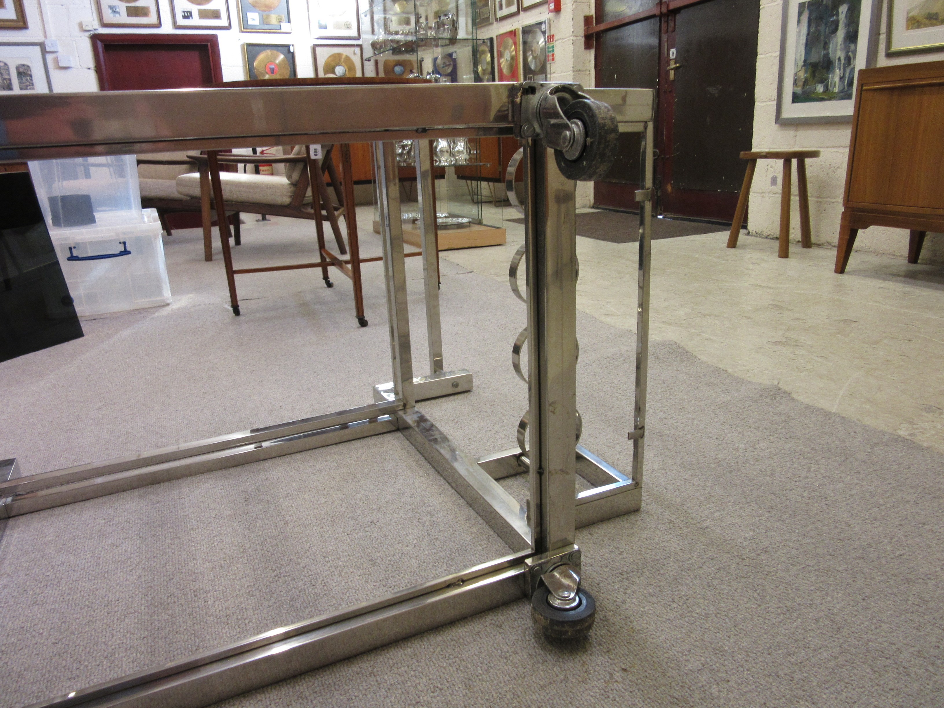AN ART DECO CHROME FRAMED TWO TIER DRINKS TROLLEY of oblong form with black glass shelves Image